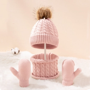 Close-up of pink cable knit hat set with fur pompom and soft thermal texture
