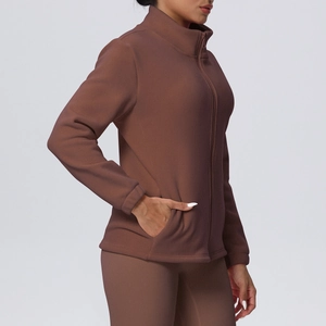 Close-up of side pocket and slim fit cut on a dark brown fleece zip-up yoga jacket