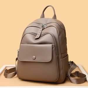 Minimalist light brown leather backpack with multiple zippers and front flap pocket