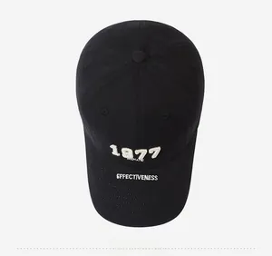 Close-up of black cotton baseball cap with white 1977 3D embroidery and fabric texture