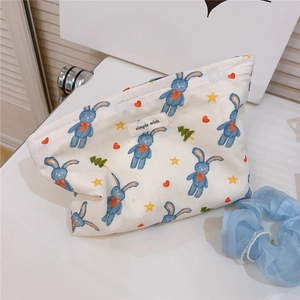 Detailed shot of bunny pattern canvas pouch with blue scrunchie on a white table