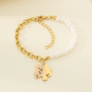 Detail of gold chain and pearl bracelet with a mother and child heart pendant