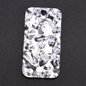 Macro shot of silver textured 304 stainless steel rectangle pendant on dark background