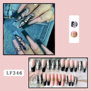 Detail of long coffin nails featuring butterfly patterns, pink gradient and gold glitter