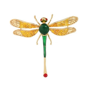 Elegant gold metal dragonfly brooch with green enamel wings and red crystal accents