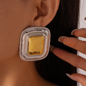 Detail of two-tone hammered metal earrings featuring gold rectangle and silver frame