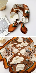 Detailed pattern of brown silk square scarf featuring white floral and geometric border