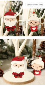 Detail of Santa and Mrs Claus wooden doll ornaments with hanging rope and red beads