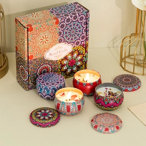 Detail view of four bohemian mandala pattern scented candle tins in a gift packaging box