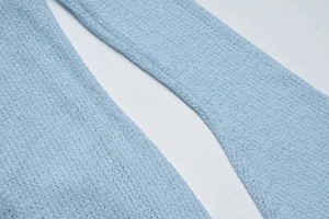Dettaglio dell'abito in maglia azzurro che mostra la trama del tessuto seersucker