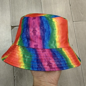 Close-up of rainbow tie-dye bucket hat showing fabric texture and stitched brim detail