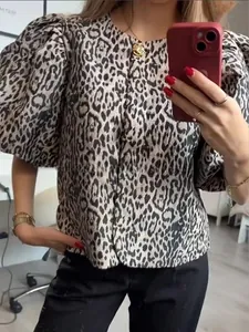 Detail of trendy leopard print top featuring stylish puff sleeves and casual round neck