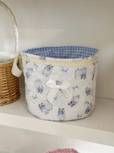 Detailed view of quilted cotton basket with blue cat prints and lace trim