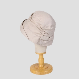 Detalle de un elegante sombrero de ramio beige con textura plisada y un lazo decorativo