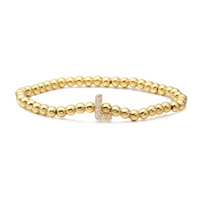 Detailed close-up of golden beaded stretch bracelet with cubic zirconia letter L charm