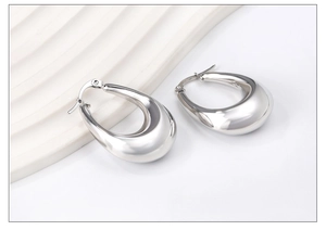 Macro shot of polished silver teardrop earrings with a sleek stainless steel finish
