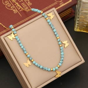 Detail of bohemian gold butterfly necklace with turquoise beads in a gift display box