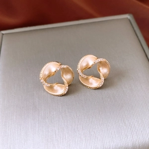 Detail of 14K gold plated spiral earrings with pavé crystals on a jewelry box