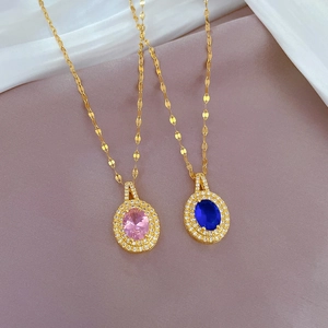 Détail des colliers goutte en titane avec zircons roses et bleus sur tissu en soie