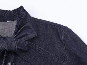 Close-up of ruffled neckline and bow detail on dark blue denim shirt for women