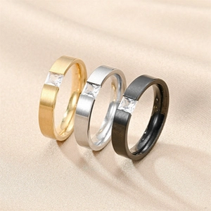 Detailed view of titanium steel rings in gold, silver, and black with square zircon