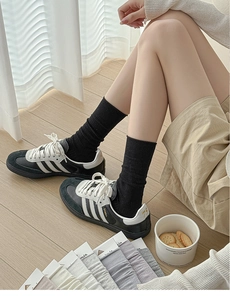 Detailed knit texture of breathable mid-calf cotton socks in black, grey, and lilac colors