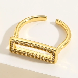 Macro detail of gold-plated open ring with rectangular frame and pavé zircon stones