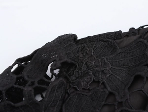 Vista macro dettagliata del tessuto in pizzo nero con motivi floreali e design traforato