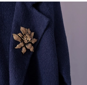 Detail of vintage flower brooch with brown crystals on a navy wool coat lapel