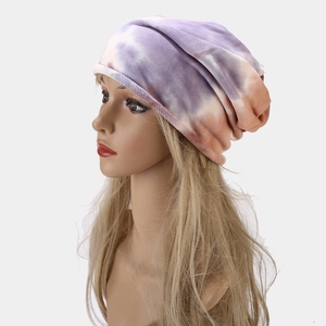 Detail of trendy tie-dye knit beanie featuring purple orange gradient pattern for women