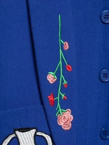 Detail of floral embroidery and matching buttons on a navy blue hooded jacket