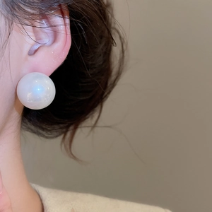Close-up of a large white pearl stud earring on model showcasing elegant minimalist style