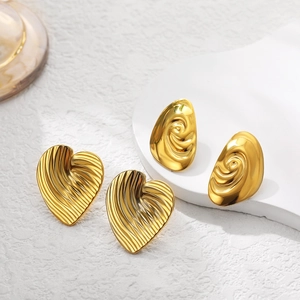 Orecchini minimalisti a cuore e spirale in oro 18 carats su supporto espositivo bianco
