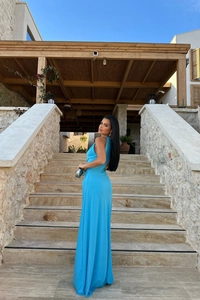 Detail of light blue backless dress showing ruched fabric and slim fit on stone background
