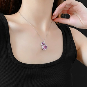 Close-up of model wearing silver hollow gourd necklace with red and clear zircon stones