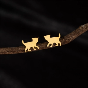 Elegant gold-plated cat silhouette stud earrings displayed on a dark wooden branch