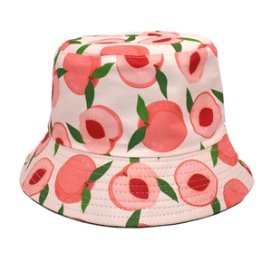 Detailed close-up of reversible bucket hat featuring peach print on light pink fabric