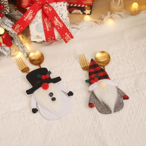 Christmas silverware holders with gnome and snowman designs on a festive table setting
