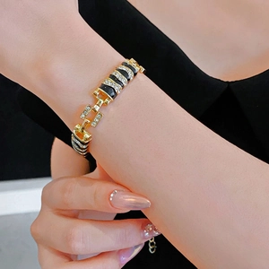 Luxe gold-plated link bracelet with black enamel, sparkling crystals, and metal clasp