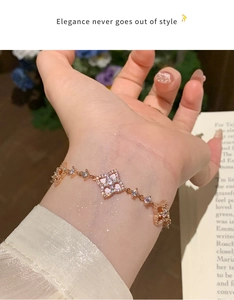 Detail of rose gold clover bracelet with sparkling zircons on a delicate chain wrist wear