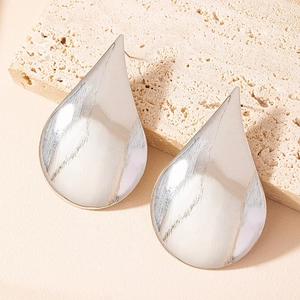 Minimalist silver teardrop stud earrings with smooth metallic finish on stone surface
