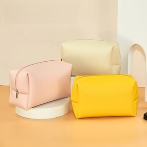 Three minimalist PU leather eyewear cases in pink, yellow, and beige with metal zippers