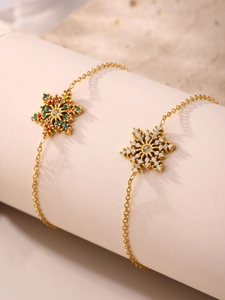 Detailaufnahme von zwei 18K vergoldeten Schneeflocken-Armbändern mit funkelnden CZ-Steinen
