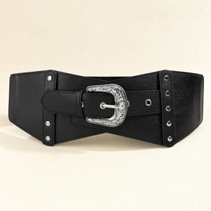 Detailed macro view of vintage carved silver buckle and rivets on black faux leather corset belt