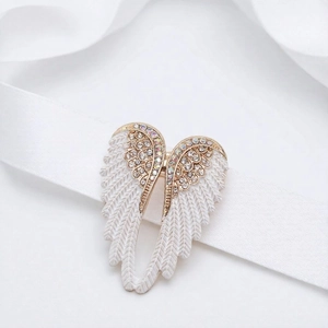 Detailed view of angel wing brooch with rainbow crystals and white matte feathers
