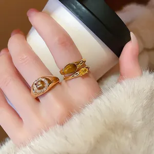 Vintage gold plated ring set with oval tiger eye stone and zircons on a hand