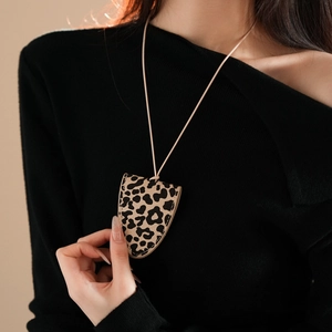 Close-up of leopard print faux leather glasses holder necklace worn by a model