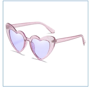 Macro shot of glittery pink heart-shaped frames with purple tinted sun lenses