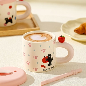 Detailed view of cat ceramic mug with pink handle and a 3D red apple decoration