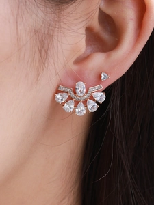 Macro detail of elegant fan-shaped rose gold earrings with crystals and imitation pearls